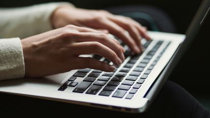 Hände tippen auf Laptop-Tastatur