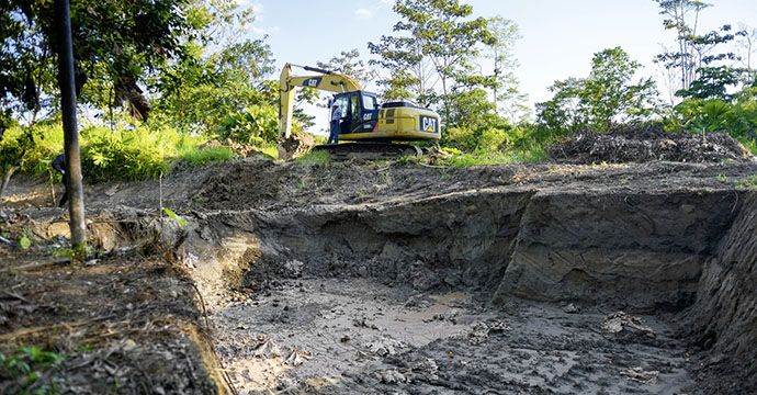 Mit Baggern wird verseuchtes Erdreich abgetragen - Regenwald, der vor über 10 Jahren nach dem Bruch einer Piepline von Öl verseucht und seither nicht nutzbar ist. Nach jahrelangem Streit ist die Erdölgesellschaft nun endlich bereit, den Schaden zu beheben und die Fläche zu reinigen, Anwesen des Ehepaares Belia Vaca (53 Jahre) und Galo Rodgrigues (63), Ort "Y del Mitad del Mundo", Provinz Sucumbíos, Ecuador; Foto: Florian Kopp / Brot für die Welt