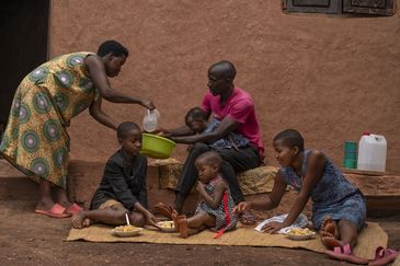 ACORD beneficiaries Kamusiime Joy, 38, her husband Kamugisha John, 45, their youngest son Levison Kamugiso, three months old, Immaculate Amatwire, 13 (right), Sheeran Akampulira, 3 (centre), and Davis Tusiime, 10 (2nd left), wash their hands prior to having lunch at their home in Kikunda 1 village, Rwampara District, western Uganda, on January 29, 2025.
