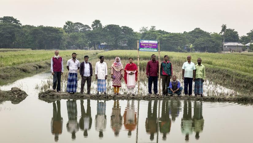 Mitarbeiterinnen von CCDB mit Dorfbewohnern auf einem Reisfeld in der Nähe von Shyamnagar