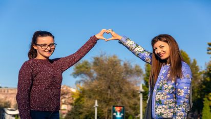 Zwei Mädchen halte die Hände gemeinsam zu einem Herz geformt.