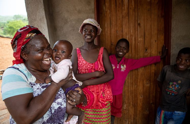Familie Dirani Gift Dirani (65) und seine Frau Evelyn (61) leben mit 5 ihrer 11 Kinder und 3 Enkelkindern auf ihrem Hof in Nyanyadzi, Chimanimani an der Ostgrenze Simbabwes. Die Region hat eine schwere Dürre erlebt und ist vom Klimawandel stark betroffen. Dadurch sind die Kleinbauern von großen Verlusten bei der Ernte und dem Viehbestand bedroht.Foto: Evelyn Dirani (61), Prosper Dirani (8 Monate), Schwiegertochter Ratidzo Maposa (18), Prosper Dirani (10), Emanuel Dirani (12, von links) Projektpartner: Towards Sustainable Use of Resources Organisation (TSURO)