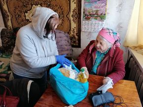 Eine Projekt-Mitarbeiterin verteilt Nahrungsmittelpakete im annektierten Odessa, Ukraine