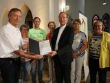 Monsignore Wolfgang Huber überreicht die Urkunde an die Partnerschaftsgruppe der Gemeinde St. Georg in Vreden.
